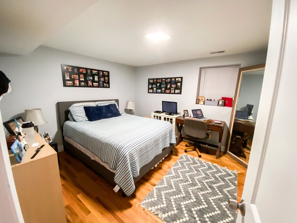 A bedroom with a bed, desk, and chair.