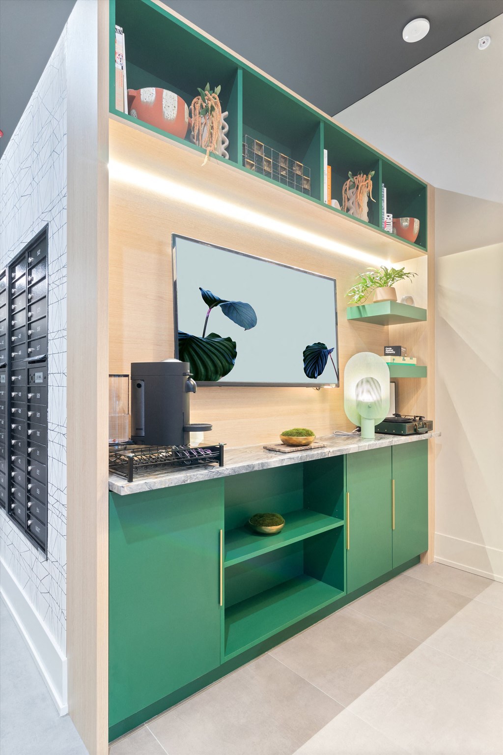 a home office with green cabinets and a large monitor on the wall