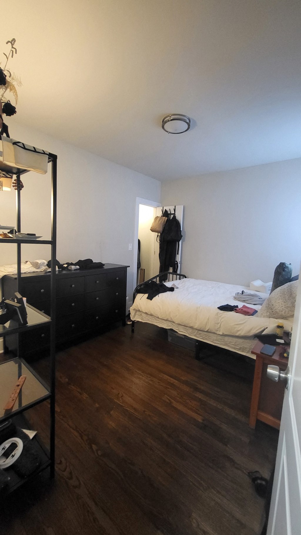 a room with a bed and a dresser in it