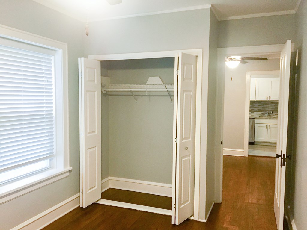 A room with a white closet and a window with blinds.
