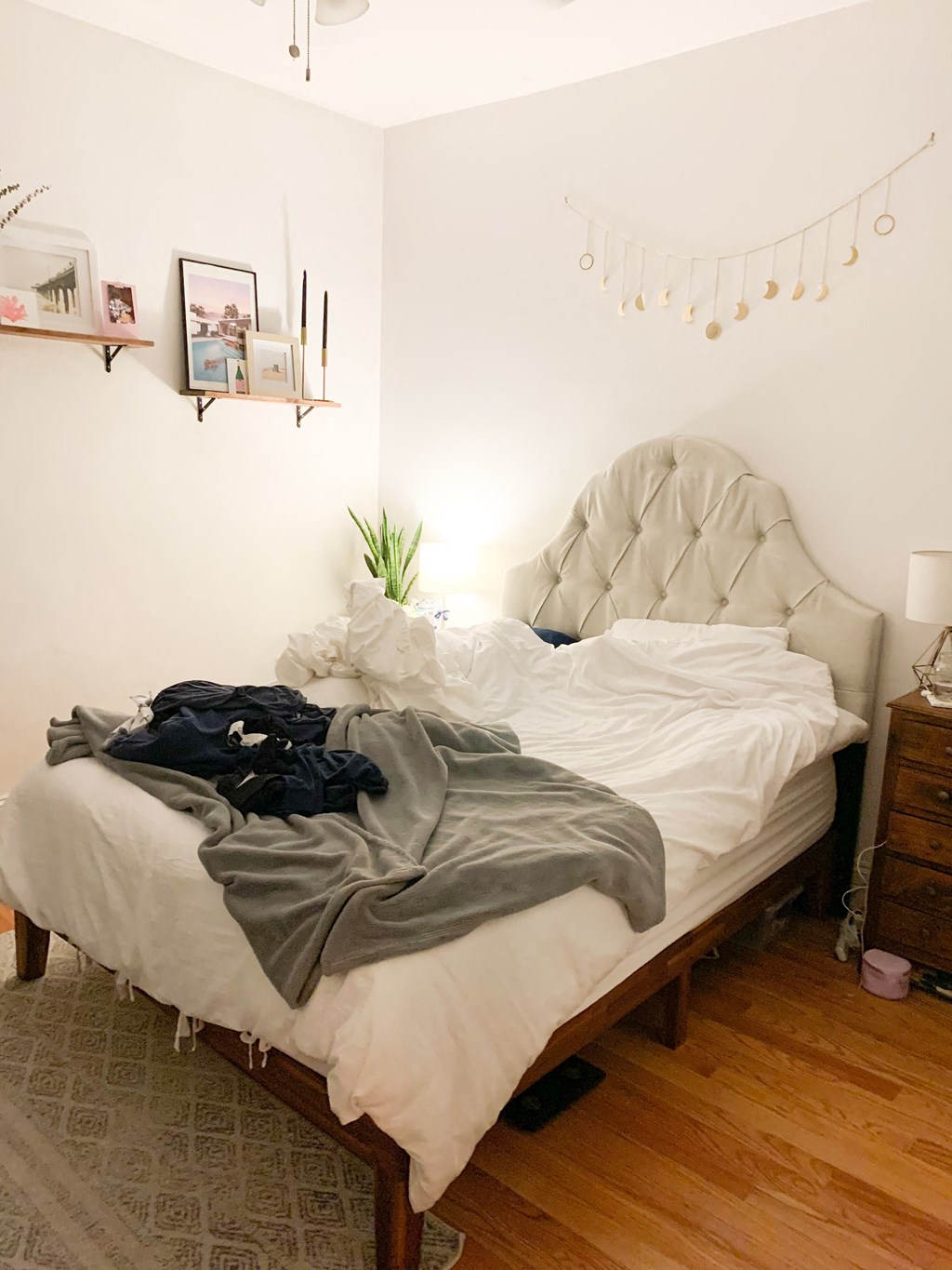 a bedroom with a bed with clothes on it