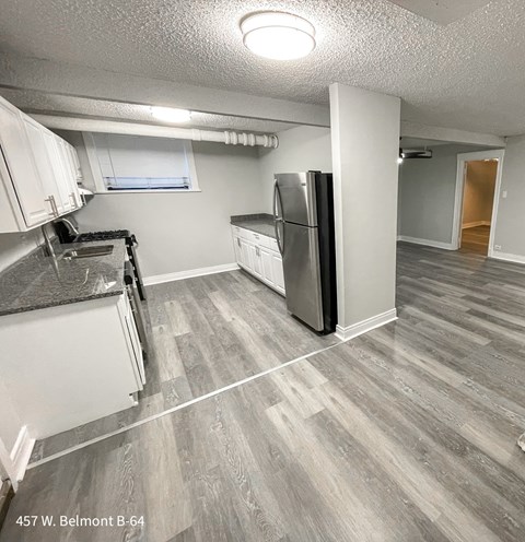 a kitchen with white cabinets and a stainless steel refrigerator