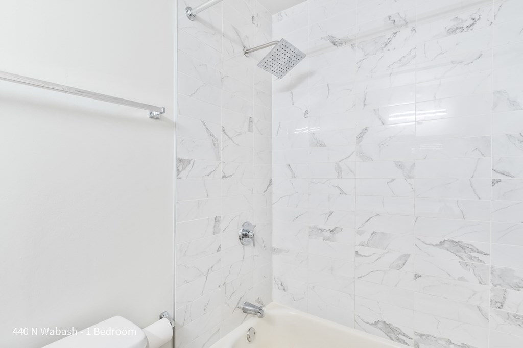 a white bathroom with a shower and a tub