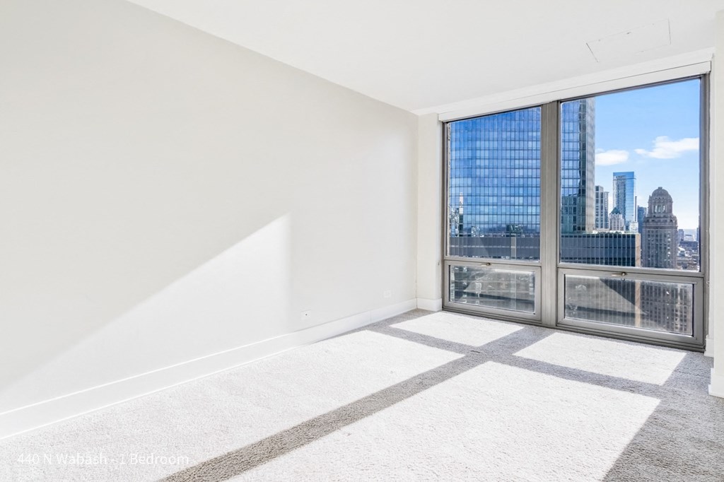 an empty living room with a large window and a view of the city
