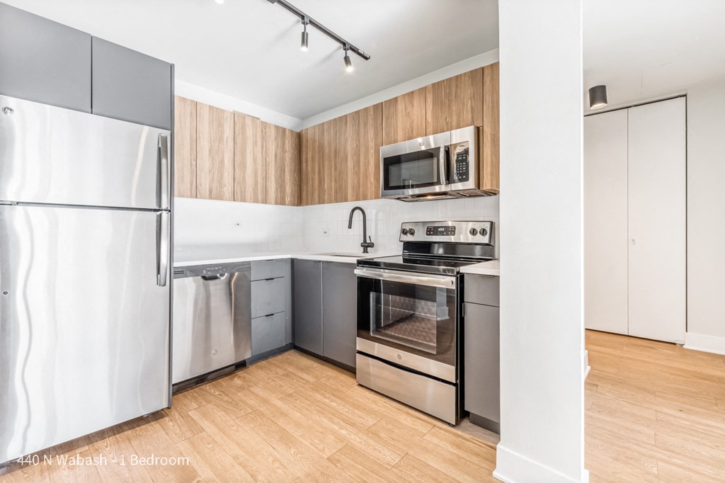a modern kitchen with stainless steel appliances and wooden floors