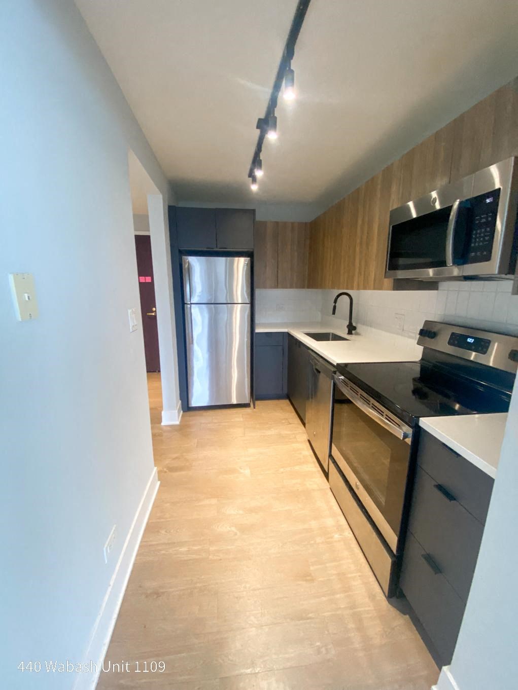 a kitchen with a stove top oven next to a refrigerator