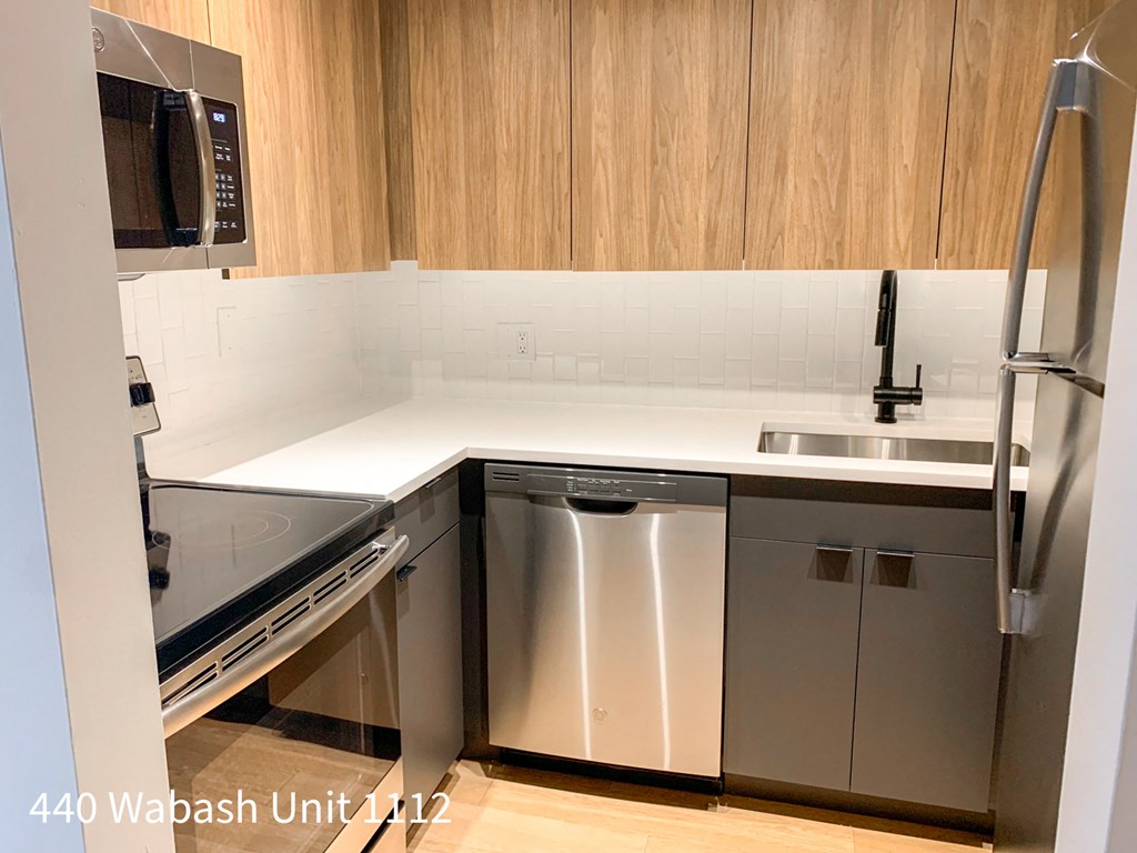a kitchen with stainless steel appliances and white counter tops