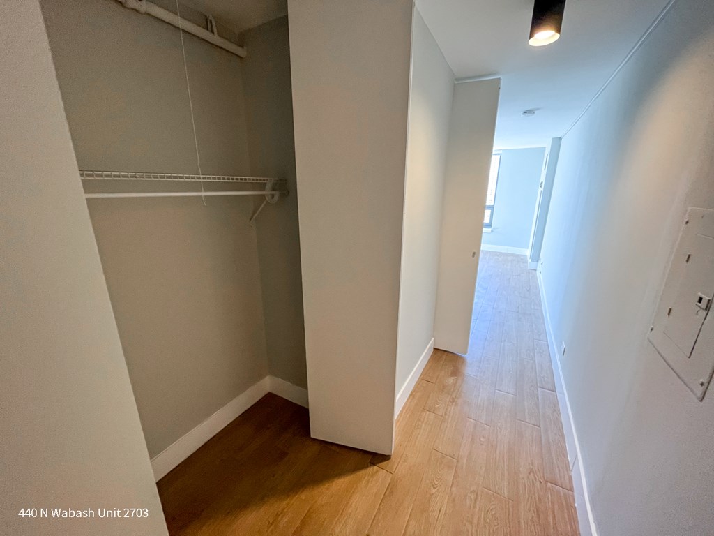 a bedroom with a closet and a hallway with a wood floor