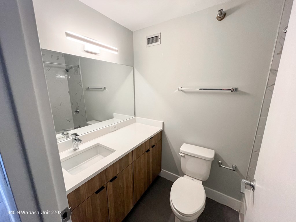 an empty bathroom with a toilet sink and mirror