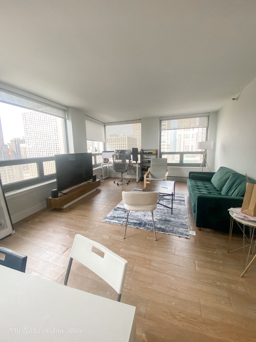 an overhead view of a living room with a green couch and white chairs