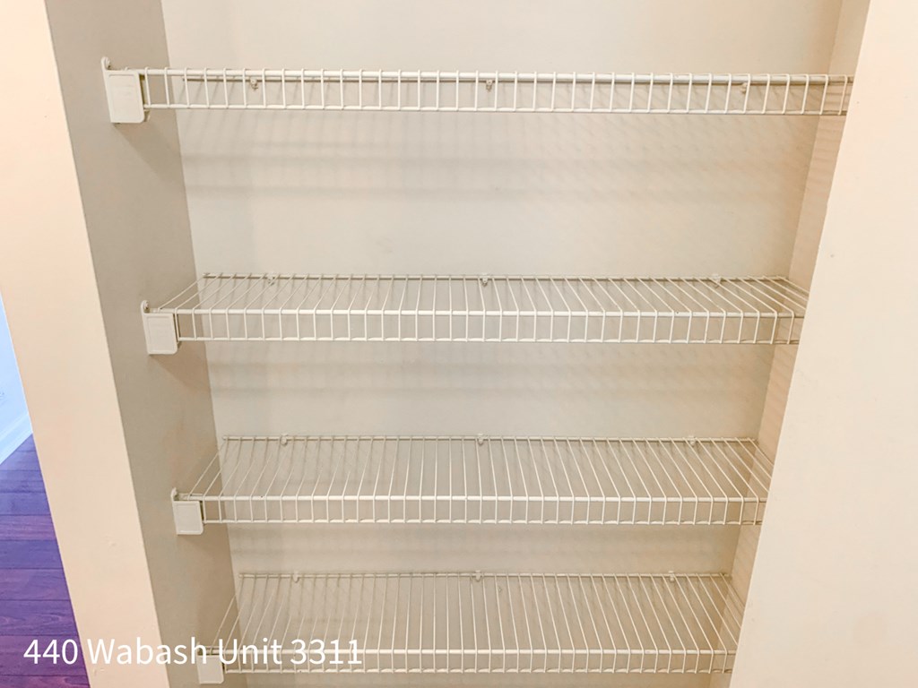 a clean closet with white shelves and white walls