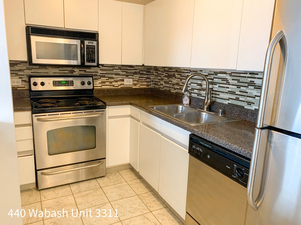 a kitchen with stainless steel appliances and white cabinets