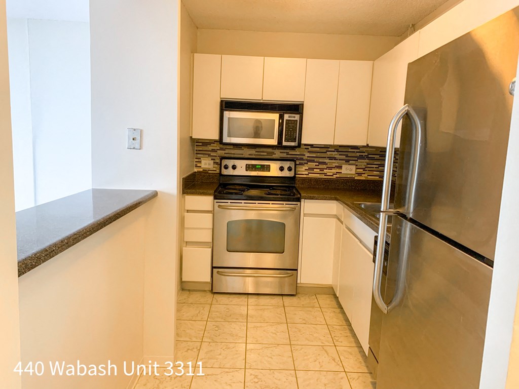 a kitchen with stainless steel appliances and white cabinets