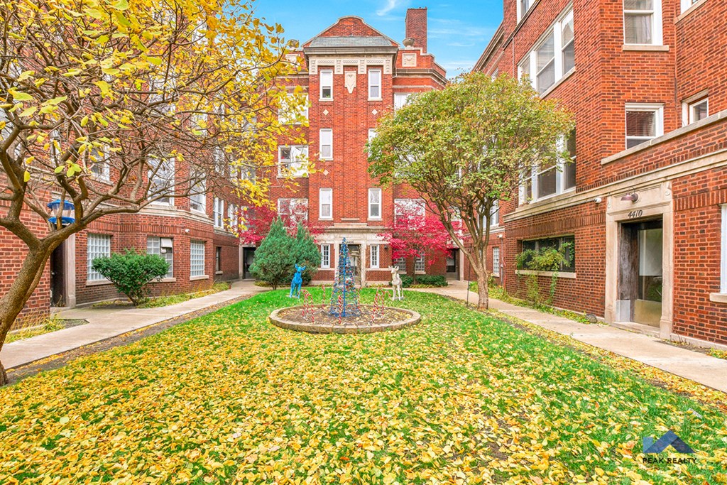 a courtyard between two brick buildings with a fountain in the middle