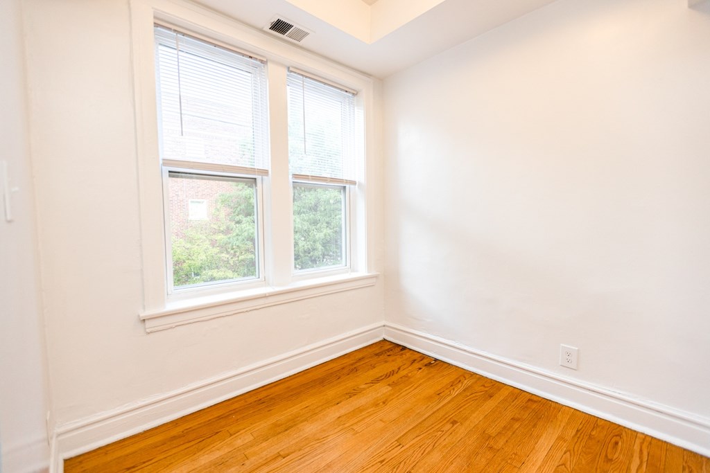 A room with a window and wooden floors.