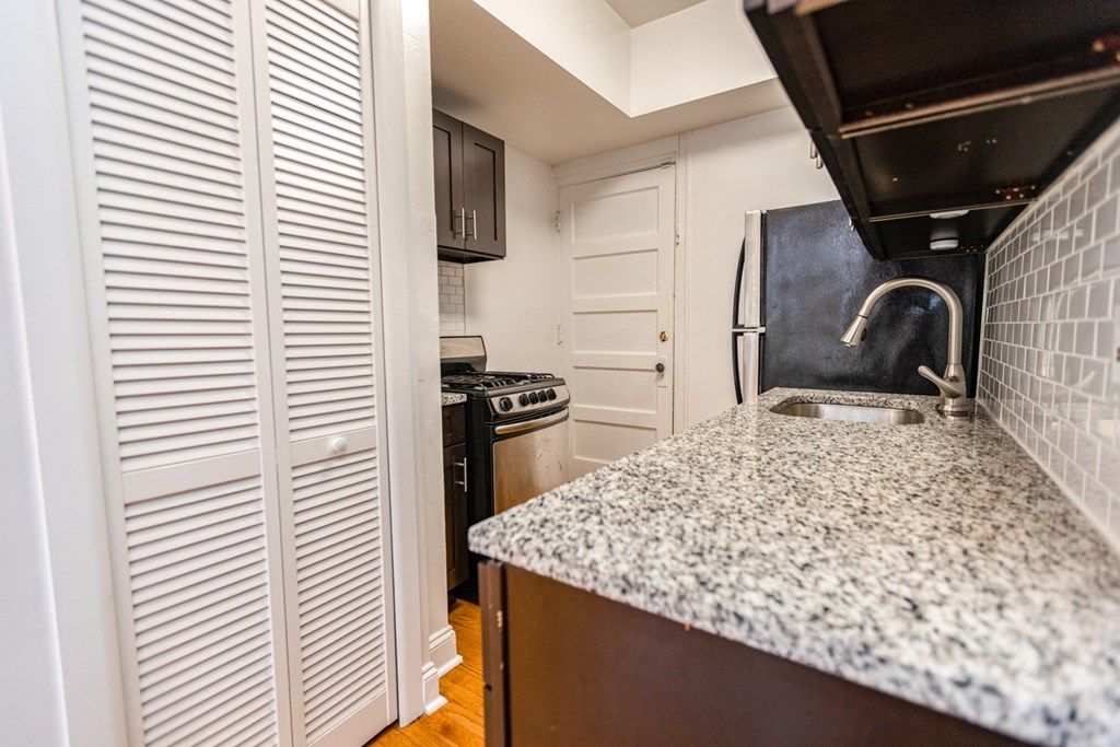 A kitchen with a granite countertop and white cabinets.