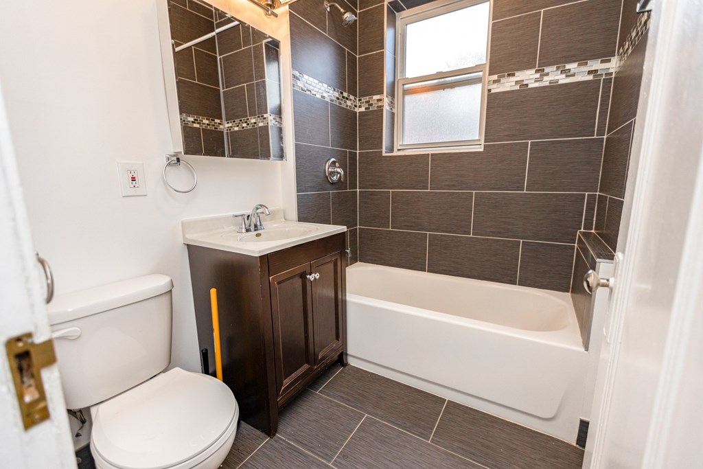 A bathroom with a toilet, sink, and bathtub.