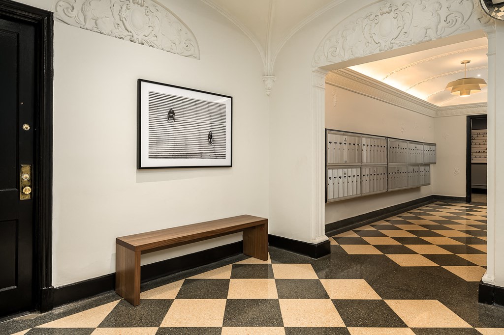 a view of a hallway with a bench and a picture on the wall