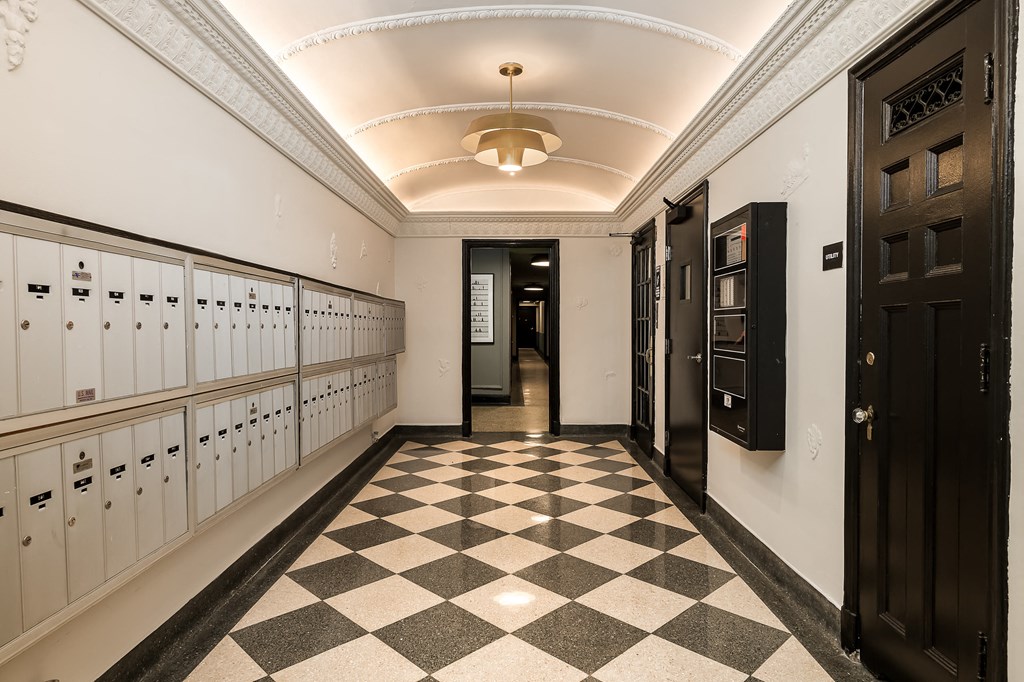 a long hallway with lockers and a checkered floor