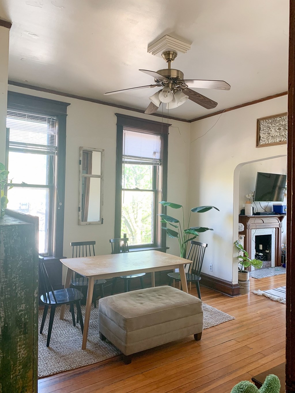 A room with a table and chairs and a fan.