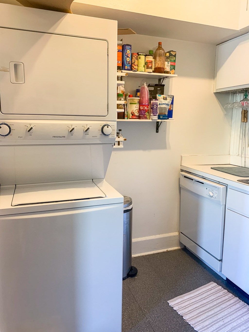 A white dishwasher is next to a white oven in a small kitchen.