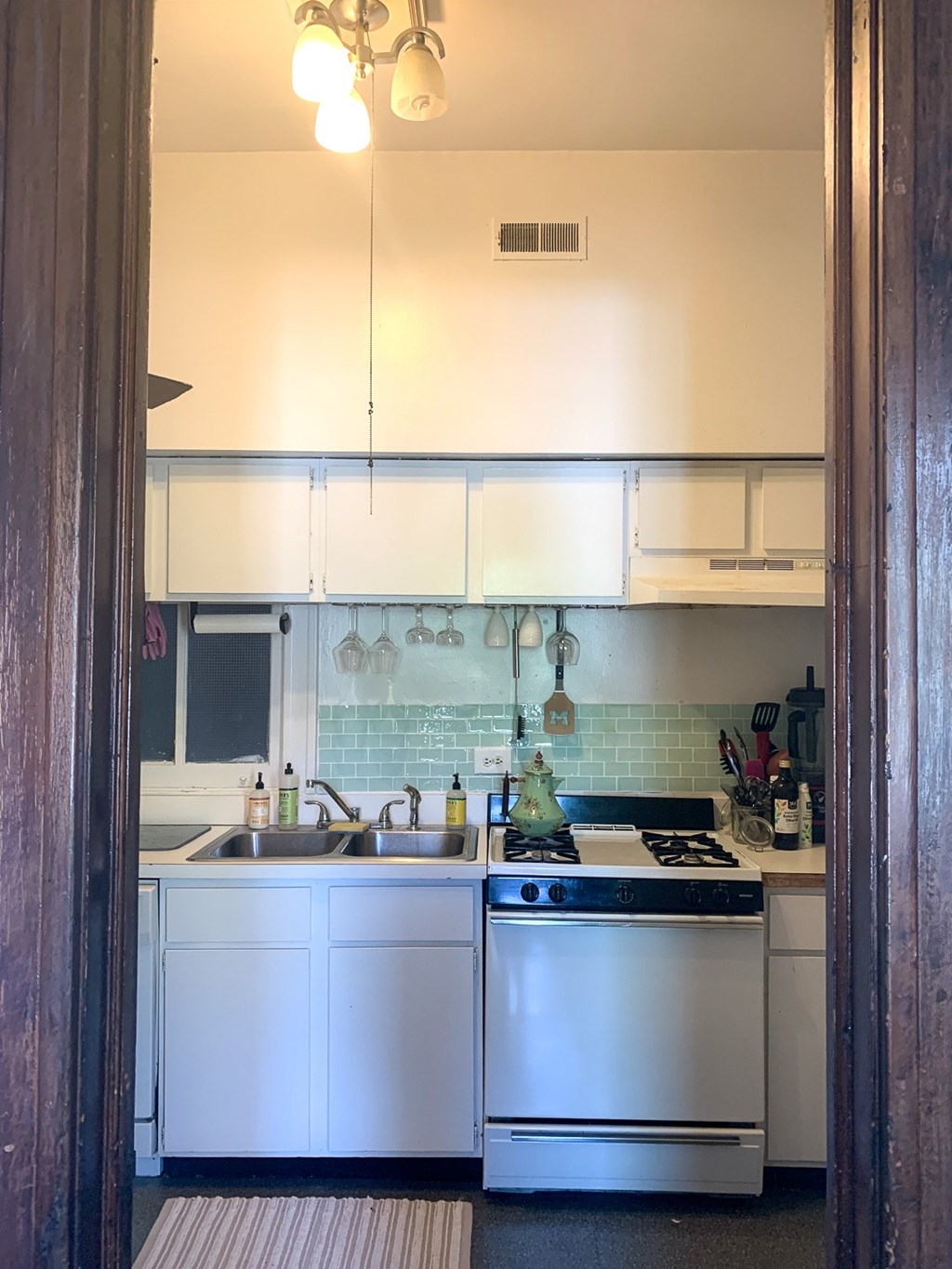 A kitchen with a white oven and sink.