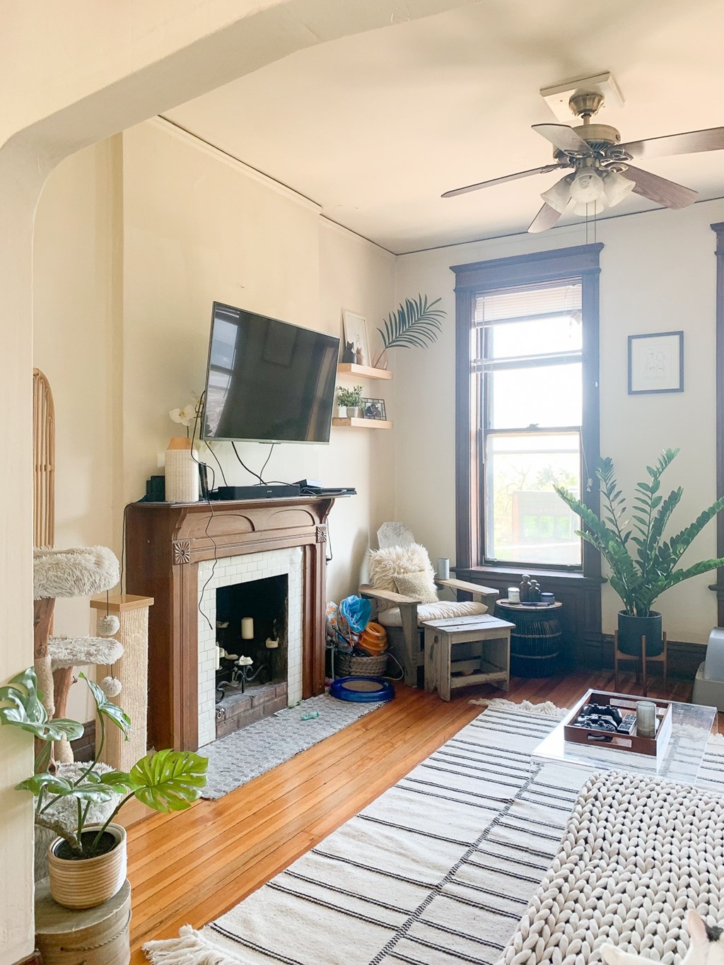 A living room with a fireplace and a television on the wall.