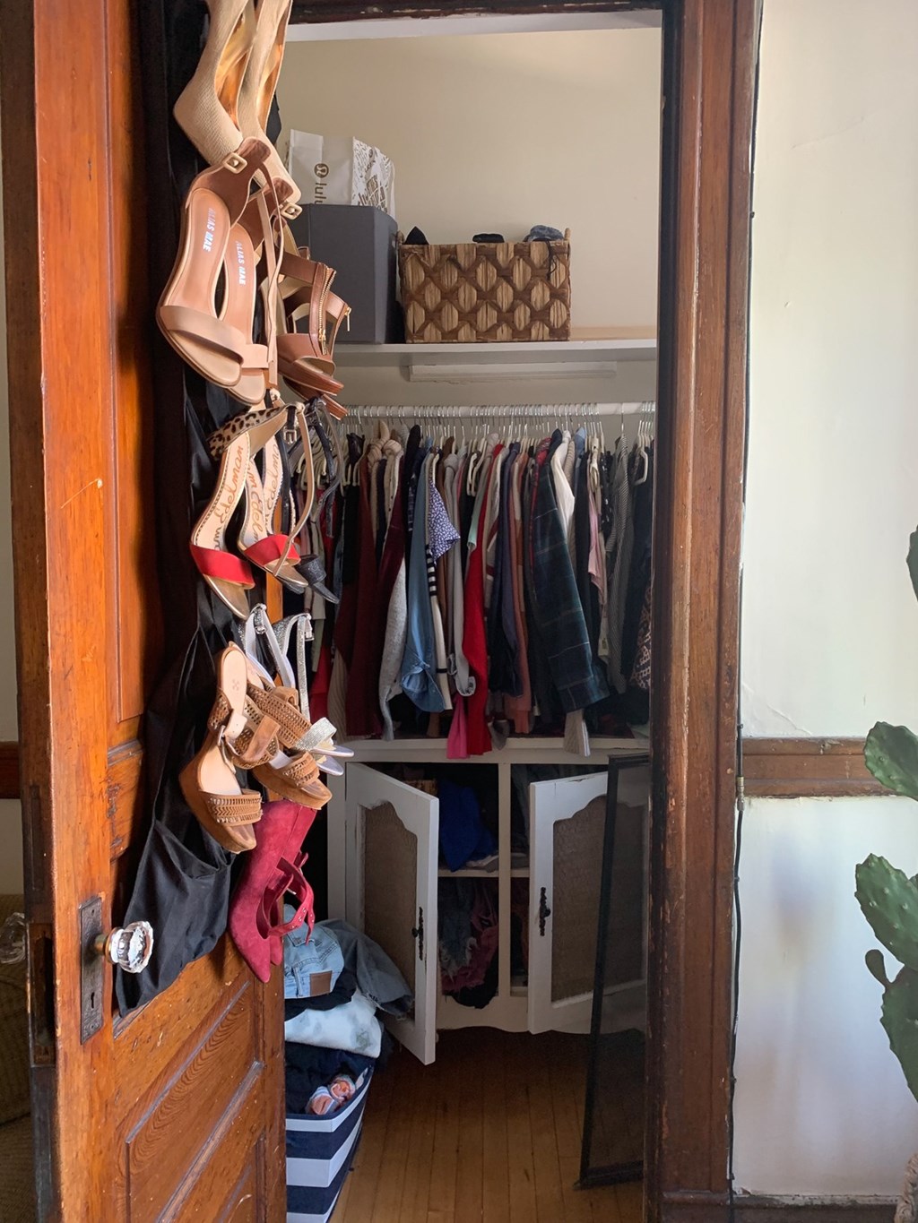 A closet with a variety of shoes hanging on the rack.