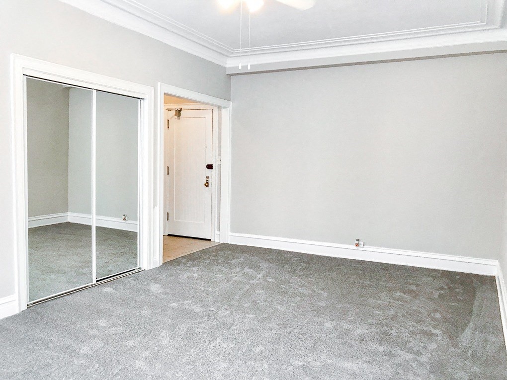 an empty room with a mirror and a carpet