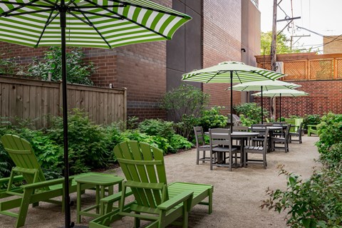 A patio with green chairs and tables.