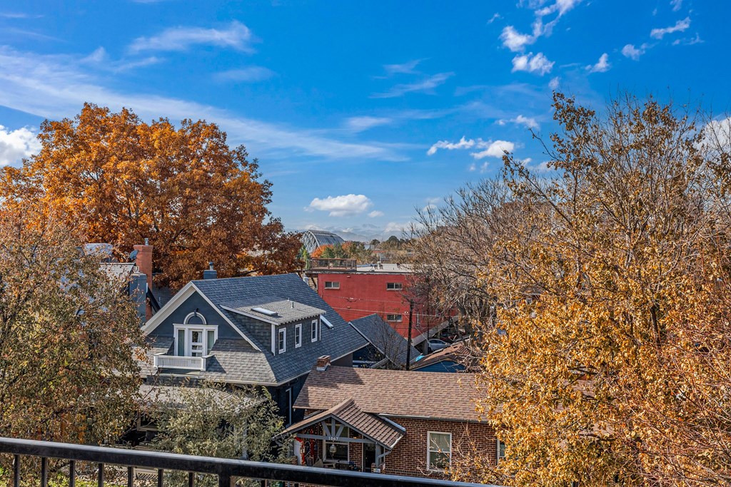 A house with a grey roof is surrounded by trees with yellow leaves.