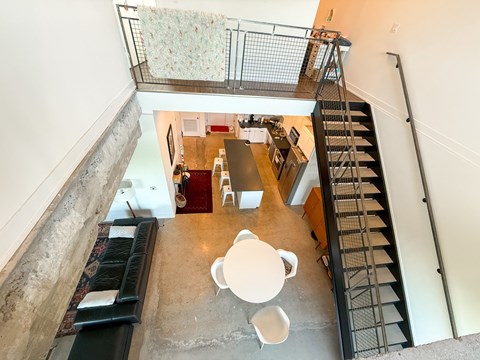A staircase with a metal railing leads up to a second floor.