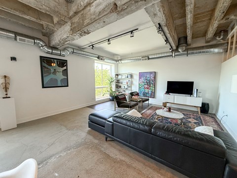 A living room with a black couch and a television.