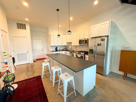 A kitchen with a bar area and white cabinets.