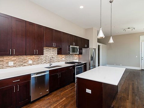 A kitchen with dark wood cabinets and a white counter top.