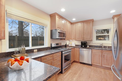A kitchen with wooden cabinets and a granite countertop.