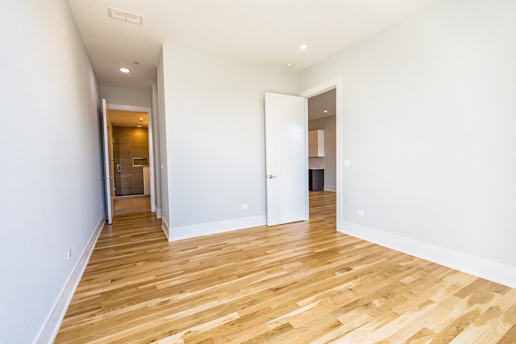 a renovated living room with white walls and wood flooring