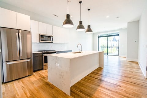 a kitchen with white cabinets and stainless steel appliances and a large island