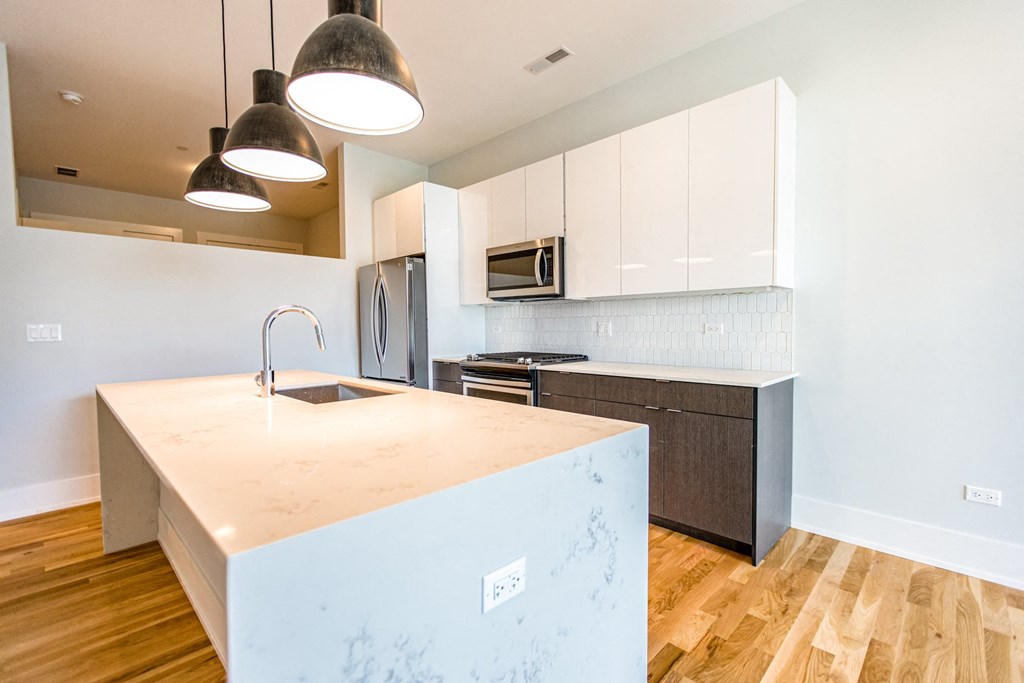 a kitchen with white cabinets and a large counter top