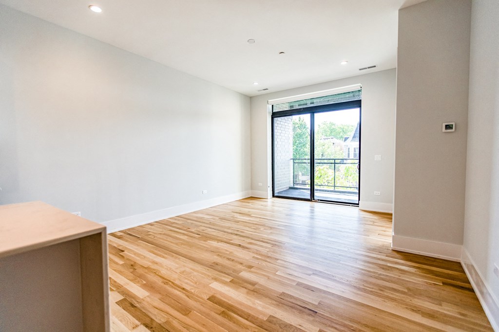a living room with a hardwood floor and a sliding glass door
