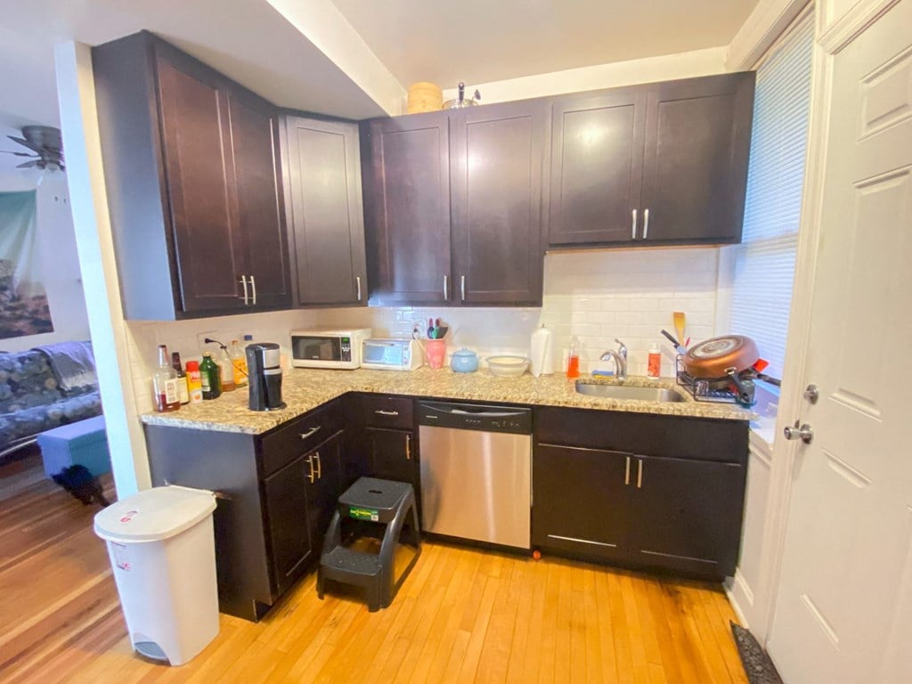 a small kitchen with black cabinets and a counter top