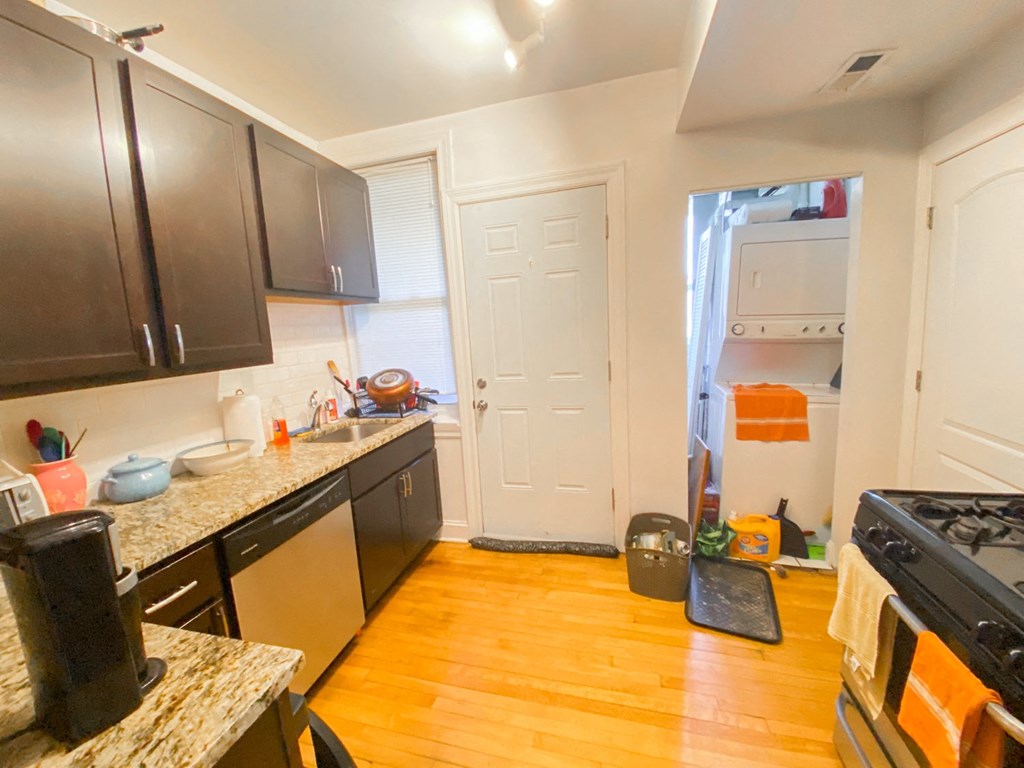 a kitchen with a door to a closet and a stove and a sink