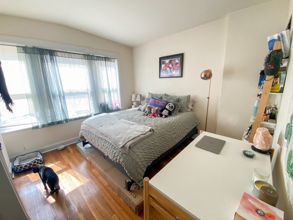 a bedroom with a bed and a desk and a window