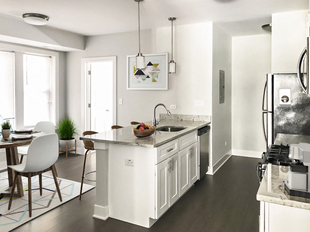 a white kitchen with a large island and a dining room
