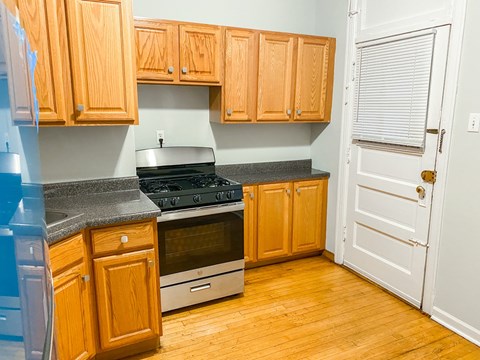 A kitchen with wooden cabinets and a stove top oven.