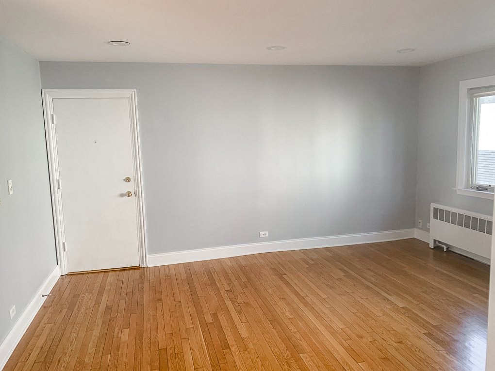 an empty room with a wooden floor and a white door