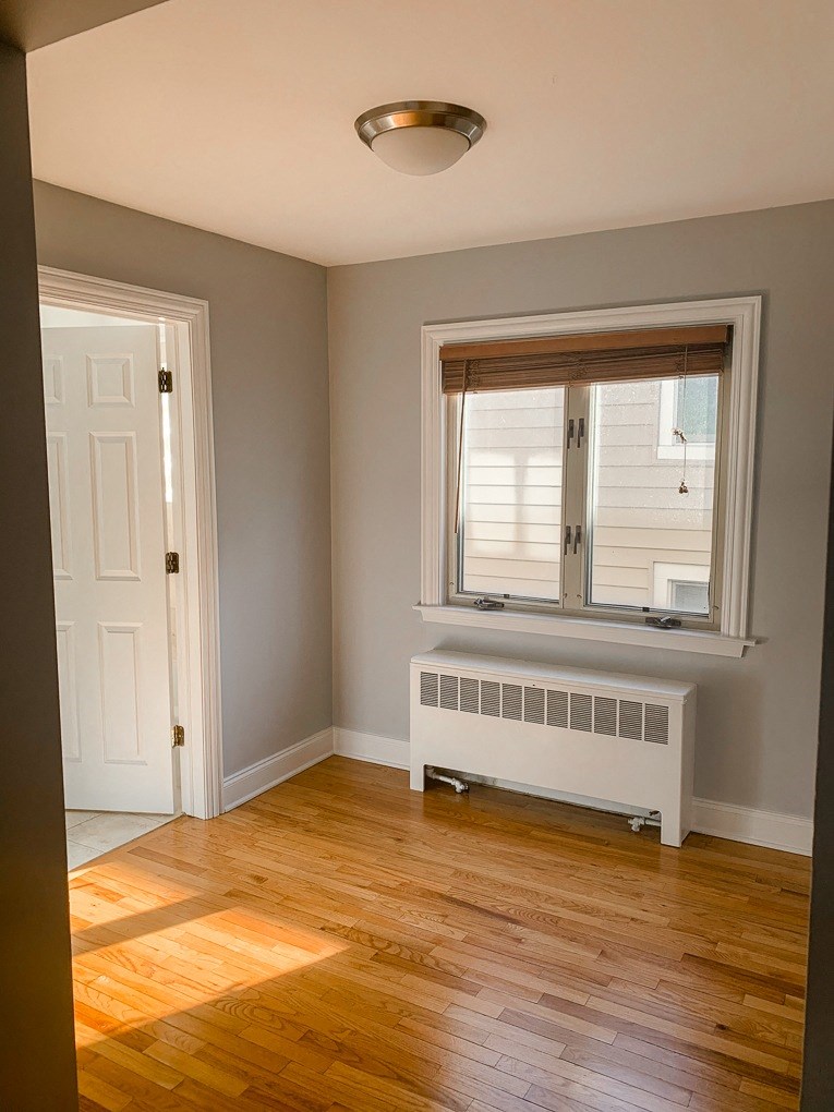 an empty room with a radiator and a window