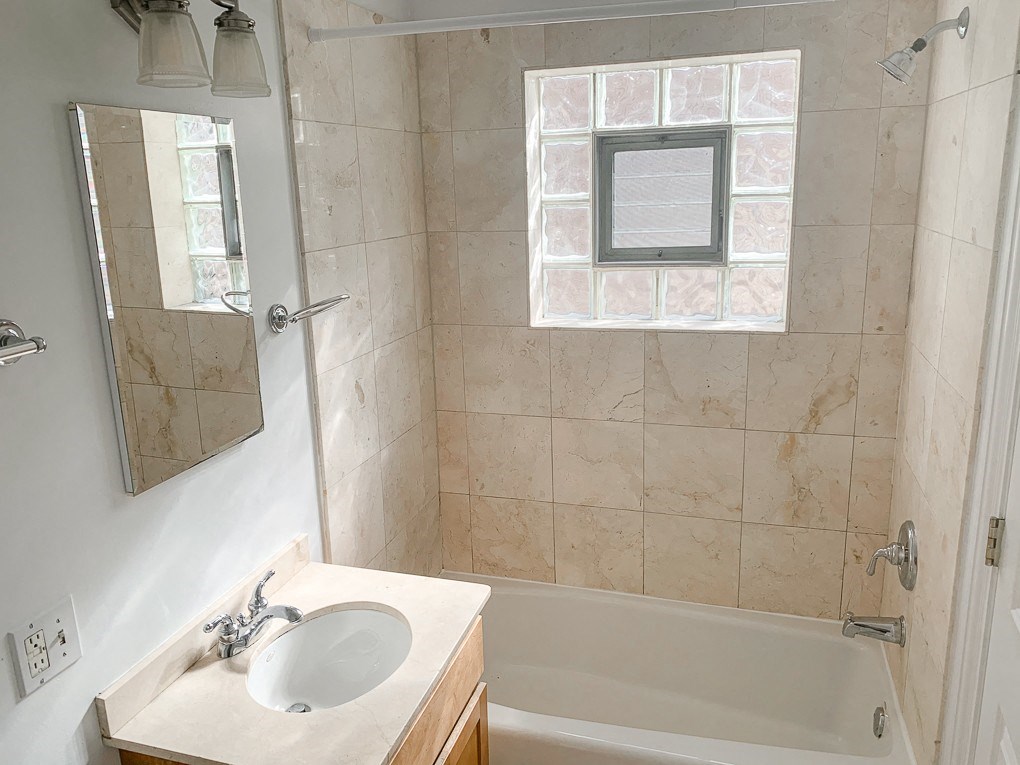 a bathroom with a sink and a tub and a window