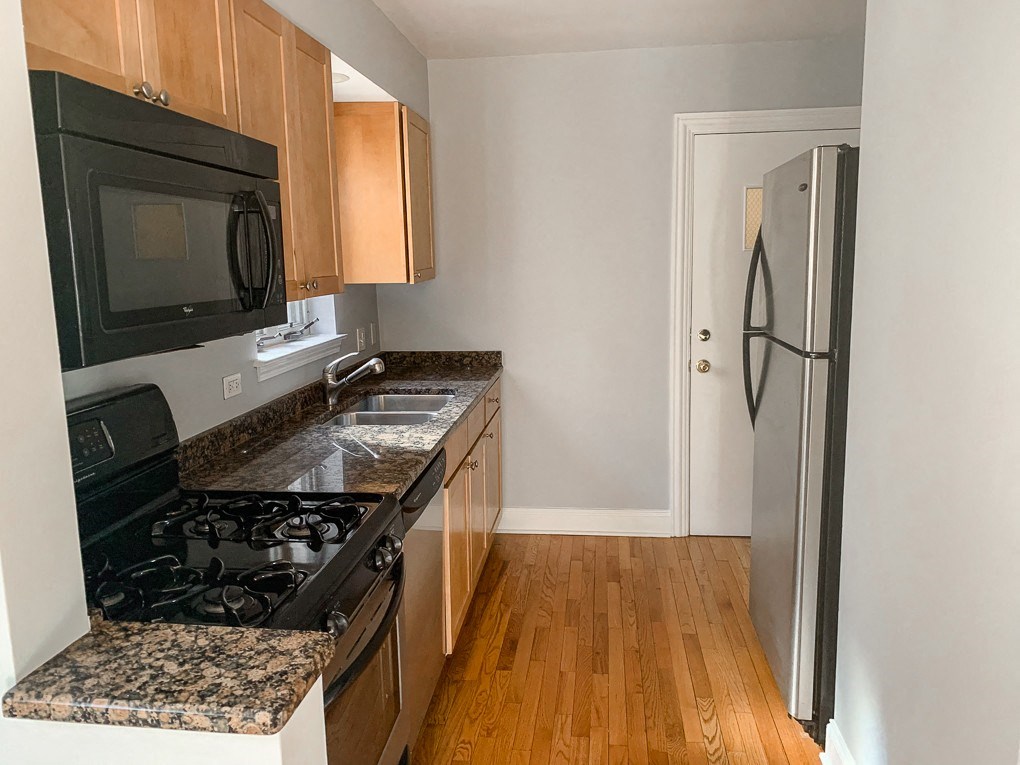 a kitchen with granite counter tops and a stove and a refrigerator