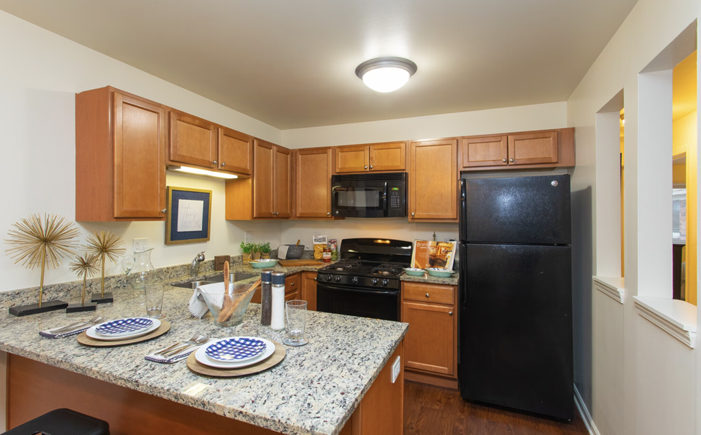 a kitchen with black appliances and granite counter tops